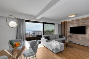 a living room with a couch and a table with chairs at 1-2. Luxury Apartments L&L Tucepi - 100m from the beach in Tučepi