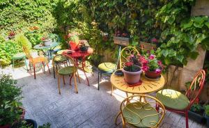 a patio with tables and chairs with plants and flowers at Hotel Bujtina Bicolli in Korçë