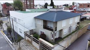 a white building with a black roof on a city street at Complejo Dolce Clementina in San Clemente del Tuyú