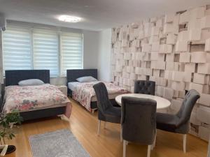 比哈奇的住宿－Apartman Citylux，一间设有两张床和一张桌子及椅子的房间