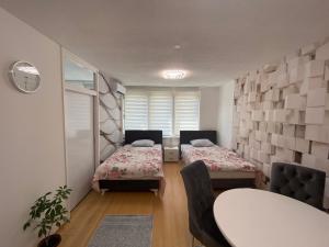 a room with two beds and a table and chairs at Apartman Citylux in Bihać