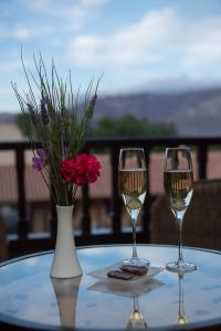 dos copas de vino y un jarrón con flores en una mesa en Estancia Colome en Molinos