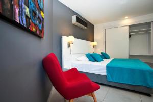 Un dormitorio con una silla roja y una cama en Green Garden Suites Hotel, en Alanya 22 fotos más