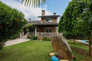 uma casa de pedra com uma pedra no quintal em Villa Albino Piscina climatizada 