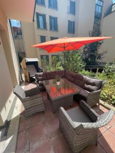 a patio with a couch and a table with an umbrella at Gästewohnung in Halle an der Saale