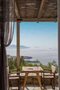 a table and chairs on a balcony with a view of the ocean at Penelope Villas in Karistos