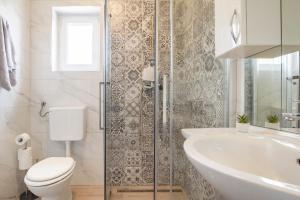 a white bathroom with a toilet and a sink at Apartmani Smokovo in Jadranovo +58 photos