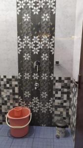 a bathroom with a tiled wall with a flower pattern at Nagas Inn by Unicorn in Krishnagiri