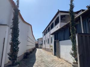 a cobblestone alley with a building and a gate at Pousada João do Táxi in Tiradentes
