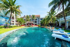 a swimming pool with lounge chairs and a resort at River Beach Resort & Residences in Hoi An