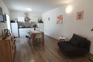 salon i kuchnia ze stołem i kanapą w obiekcie Relaxing apartment Gardens for max 8 persons in green central Istria w mieście Novaki Pazinski