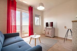 a living room with a blue couch and a table at Apartmani Smokovo in Jadranovo