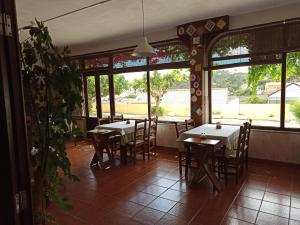 una sala da pranzo con tavoli, sedie e finestre di Porto Monte a Maceira