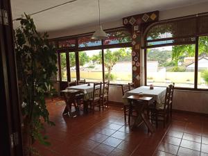 un comedor con mesas, sillas y ventanas en Porto Monte, en Maceira