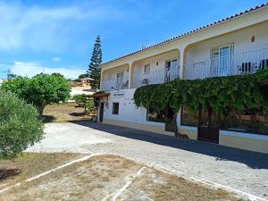 a building with vines on the side of it at Porto Monte in Maceira