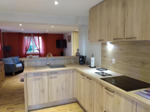 een keuken met houten kasten en een aanrechtblad bij Gîte les Eglantines Rez-de-Jardin in Gérardmer