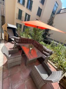 a patio with a table with an umbrella and chairs at Gästewohnung in Halle an der Saale