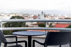 a table and two chairs on a balcony at Hotel Ponta Delgada in Ponta Delgada