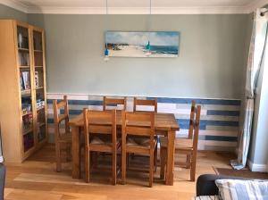 a dining room with a wooden table and chairs at Merchant House Snettisham in King's Lynn