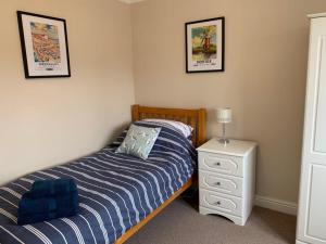1 dormitorio con 1 cama, mesita de noche y 2 fotografías en Merchant House Snettisham, en Kings Lynn