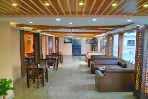 a restaurant with couches and tables and chairs at Hotel Airport Deepshree in Kathmandu