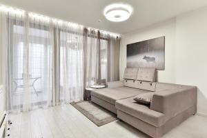 a living room with a couch and a large window at Apartmentai "Nidos Vilnelė" in Nida