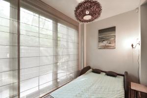 a bedroom with a bed in front of a window at Apartmentai "Nidos Vilnelė" in Nida +18 photos