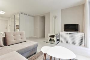 a living room with a couch and a tv at Apartmentai "Nidos Vilnelė" in Nida