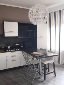 a kitchen with a table and chairs and a chandelier at Pop Apartment near Pala Alpitour in Turin