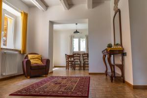 uma sala de estar com uma cadeira e uma mesa em Montenovo Country House em Ostra Vetere