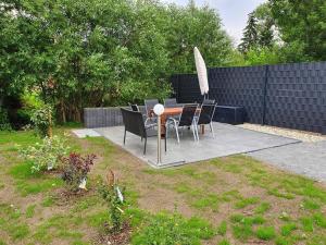 une terrasse avec une table, des chaises et un parasol dans l'établissement Ferienwohnung Am Bahnhof, à Hasselfelde