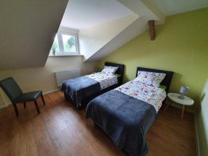 a bedroom with two beds and a table with a chair at Ferienwohnung Am Bahnhof in Hasselfelde