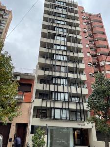 wysoki budynek apartamentowy z wieloma oknami w obiekcie Departamento Boutique III en Nueva Cordoba w Córdobie