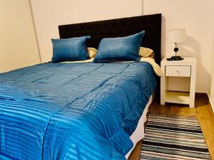 a blue bed with a blue comforter and a night stand at Departamento Boutique III en Nueva Cordoba in Cordoba
