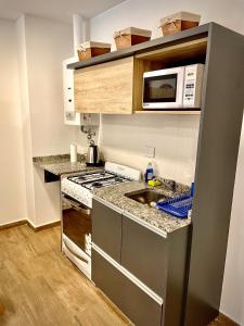 eine kleine Küche mit einer Spüle und einer Mikrowelle in der Unterkunft Departamento Boutique III en Nueva Cordoba in Cordoba