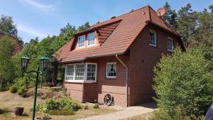 a red brick house with a red roof at Ferienhaus am Waldrand Stedden in Stedden