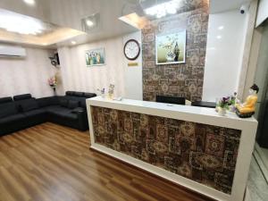a lobby with a reception desk and a couch at Nagas Inn by Unicorn in Krishnagiri