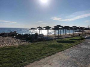 a beach with umbrellas and rocks and the ocean at Town House - Ocean View in Nikiti
