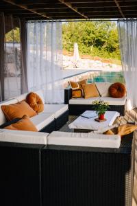eine Terrasse mit 2 Sofas und einem Pool in der Unterkunft Le Bivouac bivouacbyalain in Pimbo
