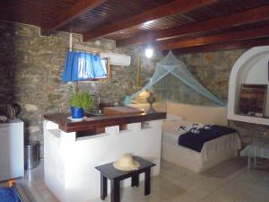 a room with a bedroom with a bed and a table at Anatoli Studios in Skhoinoussa +84 photos