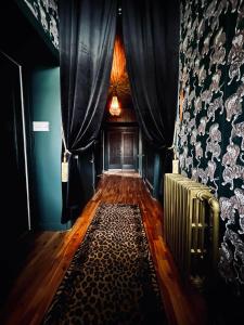 un corridoio con una stanza con tende blu e un tappeto di Auberge Du Bon Yeu a Saint-Siméon