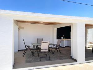 patio con mesa, sillas y TV en Chalet en Conil, descansa y disfruta, en Conil de la Frontera