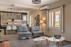een woonkamer met stoelen en een tafel en een keuken bij Villa Ktima in Argostoli