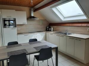 a kitchen with a table and chairs and a window at Huis Pimpernel in Bredene