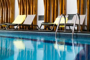 a pool with two chairs and a swimming pool at Hotel Ponta Delgada in Ponta Delgada