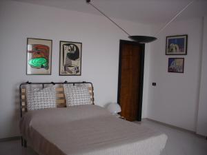 1 dormitorio con 1 cama y algunas fotos en la pared en Maria del Mar, en Monopoli