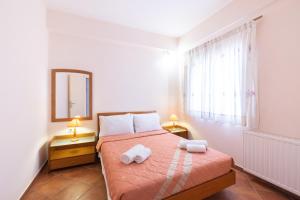 a bedroom with a bed with two towels on it at Bisti Guesthouse in Ermioni