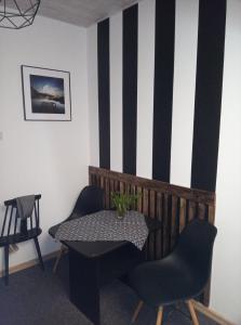 a table and chairs in a room with a striped wall at Pokoje Goscinne Na Skarpie in Jastrzębia Góra