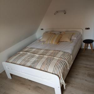 białe łóżko w białym pokoju z łóżkiem sidx sidx sidx w obiekcie Apartament Pod Bzem Puck w mieście Puck