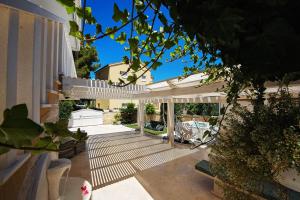 an outdoor patio with a white pergola at Casa del Mare in Rogoznica